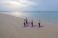 Aerial view of group of Asian women in yoga class club doing exercise and yoga at natural beach and sea coast outdoor in sport and Royalty Free Stock Photo