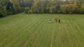 Aerial view of group of fox hunters on the horses in the autumn field. Equestrian riding sport in a countryside