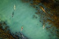 Aerial view of a group of kayakers paddling on a tranquil, turquoise-hued lake