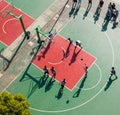 Aerial view of a group of young people playing basketball on a basketball court.