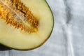 Aerial view of half green melon with seeds, on white tablecloth Royalty Free Stock Photo