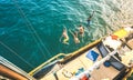 Aerial view of happy millenial friends jumping from sailboat on sea ocean trip - Rich guys and girls having fun together in Royalty Free Stock Photo