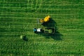 Aerial view of harvest field with tractor moving hay bale Royalty Free Stock Photo