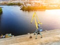Aerial view of heavy crane loading bulk goods at Dnieper river cargo port terminal in Kiev at evening sunset time. Industrial Royalty Free Stock Photo