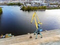 Aerial view of heavy crane loading bulk goods at Dnieper river cargo port terminal in Kiev at evening sunset time. Industrial Royalty Free Stock Photo