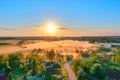 Aerial view height landscape sun above horizon, forest village with flying birds. Morning fog in the meadows mouth of the river