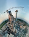 Aerial view from high altitude of little planet earth with cement factory high concrete structure and tower crane at Royalty Free Stock Photo