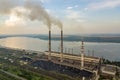 Aerial view of high chimney pipes with grey smoke from coal power plant. Production of electricity with fossil fuel