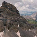 Aerial view of a High mountain valley with some snow spots down the mountain clouds in the sky and green grass far away Royalty Free Stock Photo