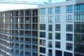 Aerial view of high residential apartment building under construction. Many windows on new apartment building facade under