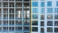 Aerial view of high residential apartment building under construction. Many windows on new apartment building facade