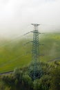 Aerial view of the high voltage power lines and high voltage electric transmission on the terrain in clouds surrounded Royalty Free Stock Photo