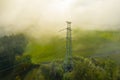 Aerial view of the high voltage power lines and high voltage electric transmission on the terrain in clouds surrounded Royalty Free Stock Photo