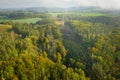 Aerial view of the high voltage power lines and high voltage electric transmission on the terrain surrounded by trees at Royalty Free Stock Photo