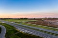 Aerial view of a highway passing through fields at sunrise Royalty Free Stock Photo
