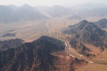 Aerial view of a highway road curving between treeless rocky mountains and desert on the south of Sinai Peninsula near Royalty Free Stock Photo