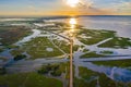 Aerial view of highway during sunrise in the middle of swamp