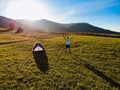 Aerial view of hiker man with arms outstretched celebrating praying in beautiful sunrise with mountains. Royalty Free Stock Photo