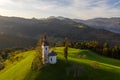 Aerial view of hills, colorful forest and Sv Tomaz church. Sunset in Slovenia in autumn