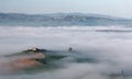 Aerial view of hilltop farmhouses & cypress trees in Tuscany on a foggy spring morning Royalty Free Stock Photo