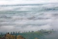 Aerial view of hilltop farmhouses & cypress trees in Tuscany on a foggy spring morning ~ Royalty Free Stock Photo