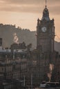 Aerial view of a historic clock tower in the center of a bustling cityscape of Edinburgh, UK