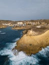 Xlendi tower on the rock and rough waves at Xlendi bay aerial Gozo Malta Royalty Free Stock Photo