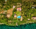 an aerial view of a home surrounded by green plants and trees