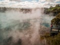 Aerial view of hot spring and a woman wearing face mask on lookout. Tourism and pandemic concept Royalty Free Stock Photo