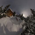 Aerial view house chalet during a snowfall in the trees winter forest at night in the moonlight Royalty Free Stock Photo