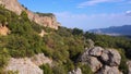 Aerial view of huge rocky formations on a forested mountains slopes.