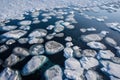 an aerial view of ice floes floating in the water near the shore of a frozen lake in the snow covered landscape of the arctic