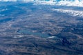 Aerial View of Idaho mountains and lake lowell from the sky while inside an airplane. View of brown mountains and trees covered