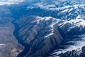 Aerial View of Idaho mountains and snake river from the sky while inside an airplane. View of brown mountains and trees covered