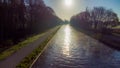 Aerial view of an Idillic river stream canal with grass banks and wild flowers and trees in a scenic landscape on a Royalty Free Stock Photo