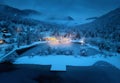 Aerial view of illuminated houses in snowy village at night Royalty Free Stock Photo