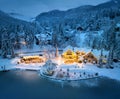 Aerial view of illuminated houses in snowy village at night Royalty Free Stock Photo
