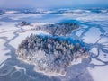 Aerial view of the winter snow covered forest and frozen lake from above captured with a drone in Lithuania. Royalty Free Stock Photo