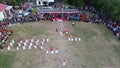 Aerial view of Indonesian flag lowering ceremony witnessed by villagers. Indonesia Independence Day