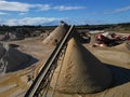 Industrial stone crusher machines on quarry site with cone heaps of sand Royalty Free Stock Photo