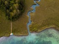 Aerial view on inflow through reeds to Lake `Faaker See` in Carinthia Kaernten, Austria with canoes and a jetty with a