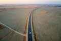 Aerial view of intercity road with blurred fast driving car at sunset. Top view from drone of highway traffic in evening