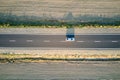 Aerial view of intercity road with blurred fast driving environment friendly electric car at sunset. Top view from drone Royalty Free Stock Photo