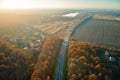 Aerial view of intercity road with fast driving cars between autumn forest trees at sunset. Top view from drone of Royalty Free Stock Photo