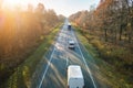 Aerial view of intercity road with fast driving cars between autumn forest trees at sunset. Top view from drone of Royalty Free Stock Photo