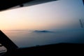 Aerial view of an island surrounded by mist at sunset Royalty Free Stock Photo