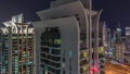 Aerial view of JLT and Dubai marina skyscrapers with glowing windows night timelapse with traffic on sheikh zayed road. Royalty Free Stock Photo