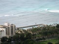 Aerial view of Kapiolani Park, Natatorium, and waves on the Pacific ocean