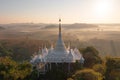 Aerial view of Khao Na Nai pagoda stupa. Luang Dharma Temple Park with green mountain hills and forest trees, Surat Thani,