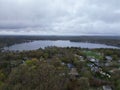 Aerial view of lake Attitash and a town near a shoreline surrounded by colorful trees in autumn Royalty Free Stock Photo